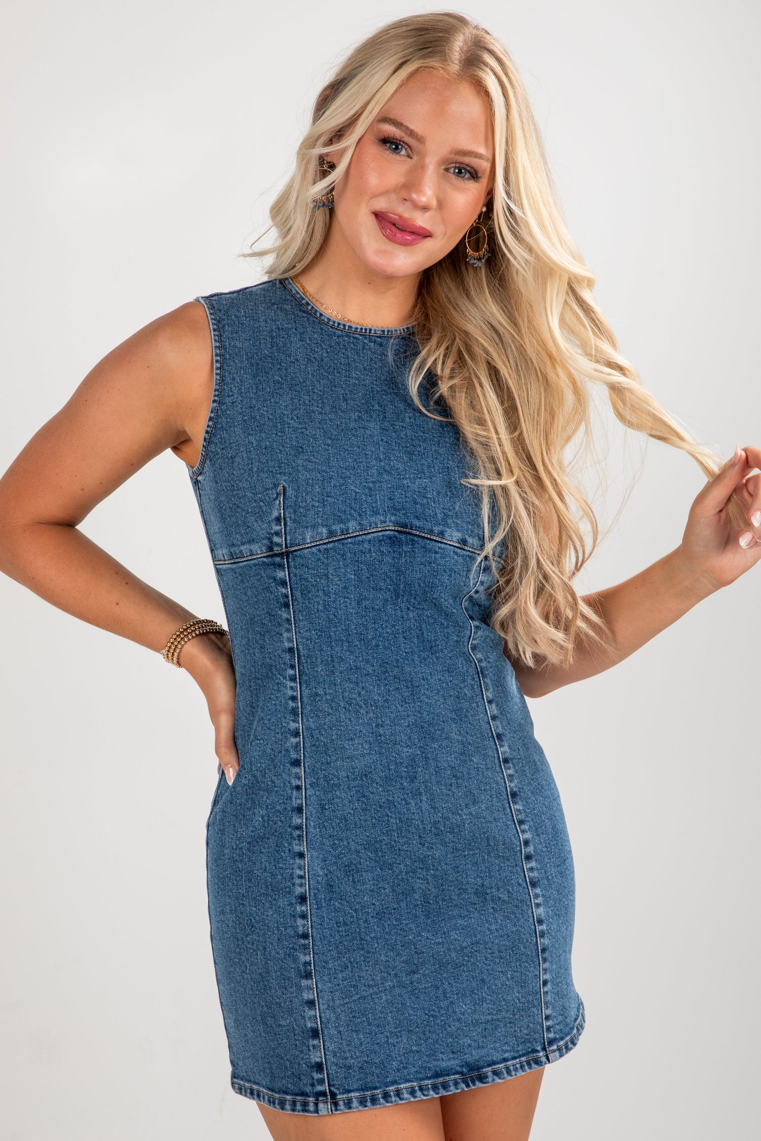 Woman wearing a denim dress against a plain background