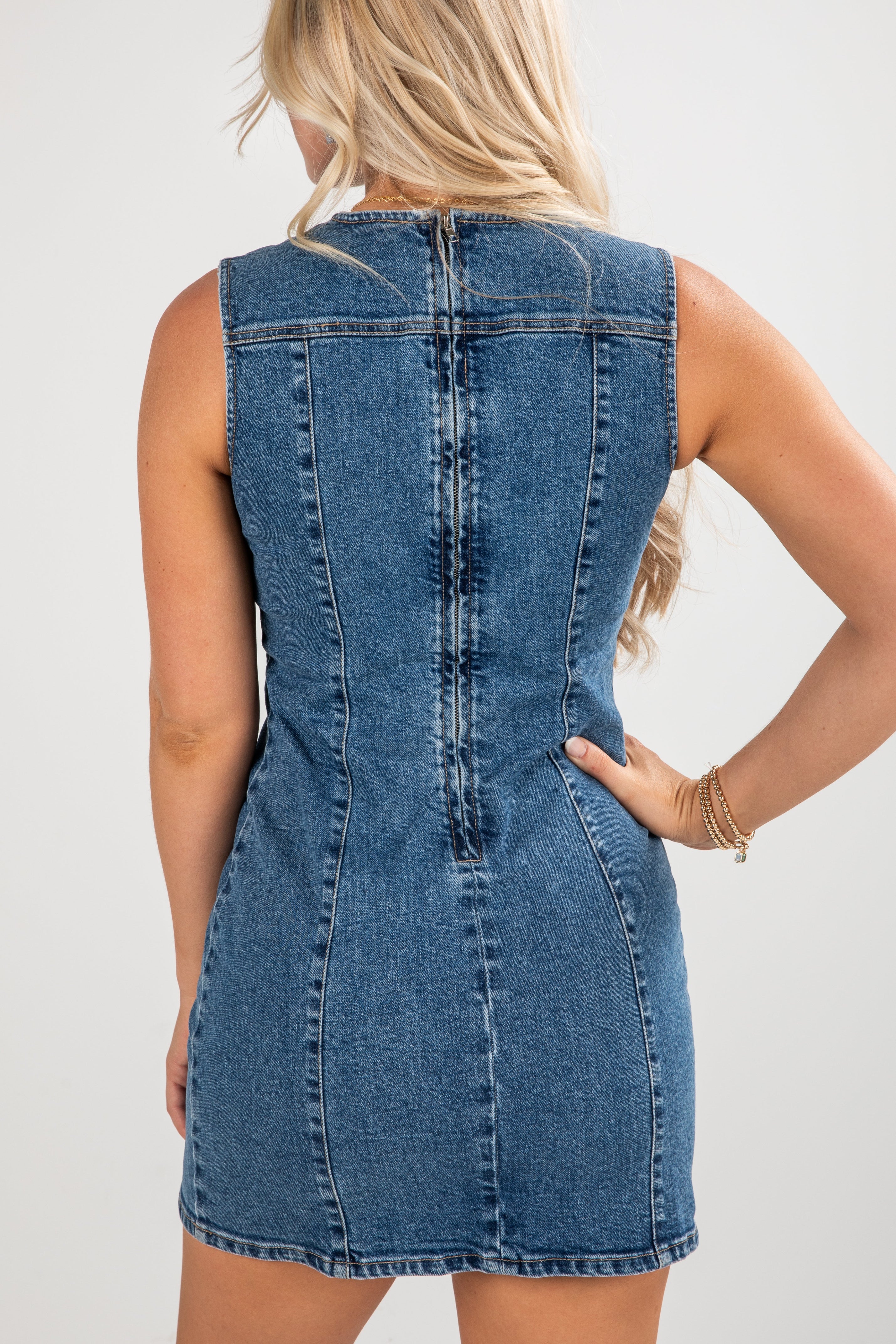 Denim dress worn by a person on a plain background