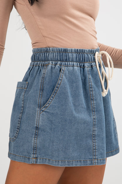 Denim skirt with drawstring waist on a plain background