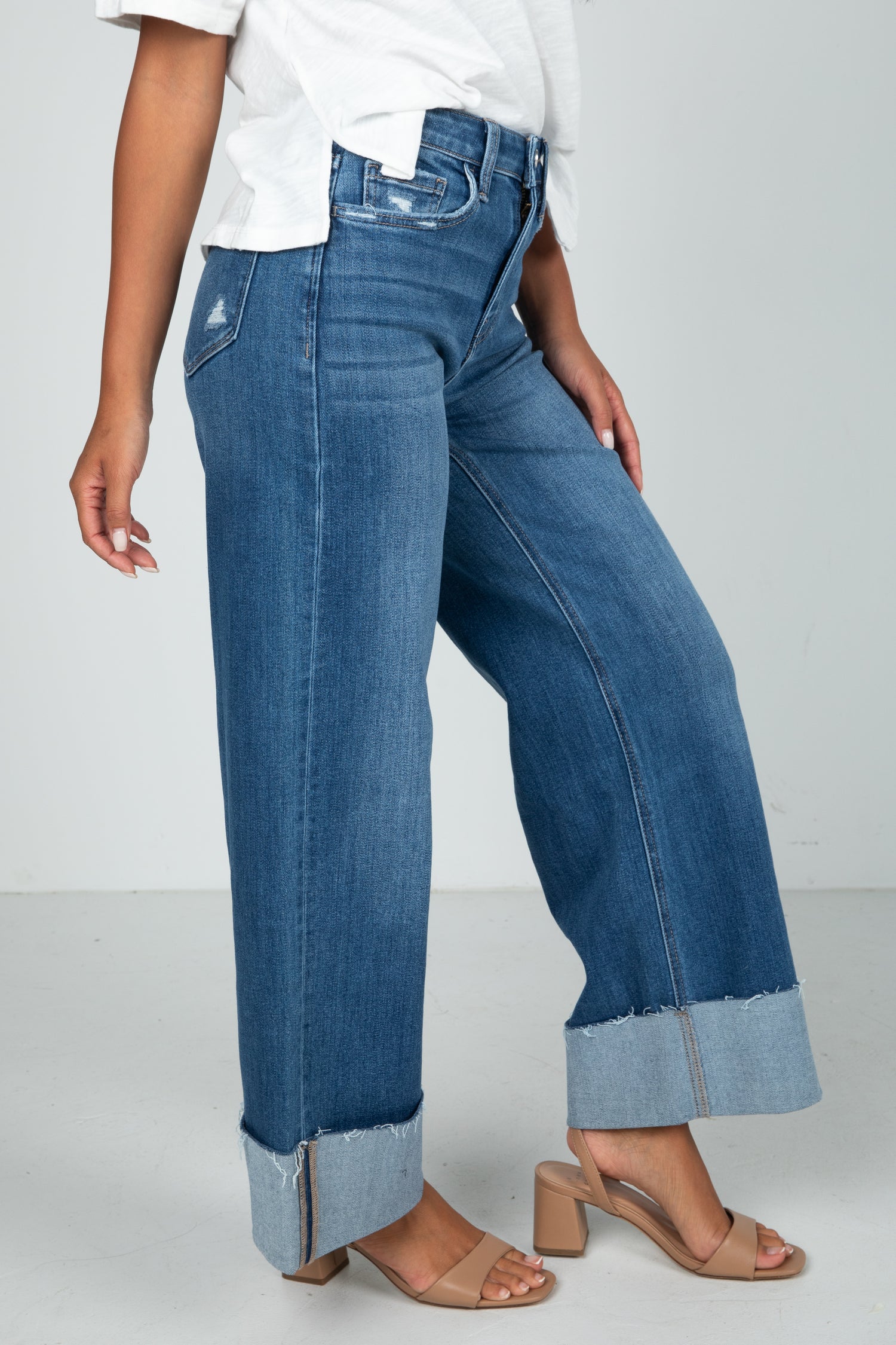Person wearing blue wide-leg jeans on a white background