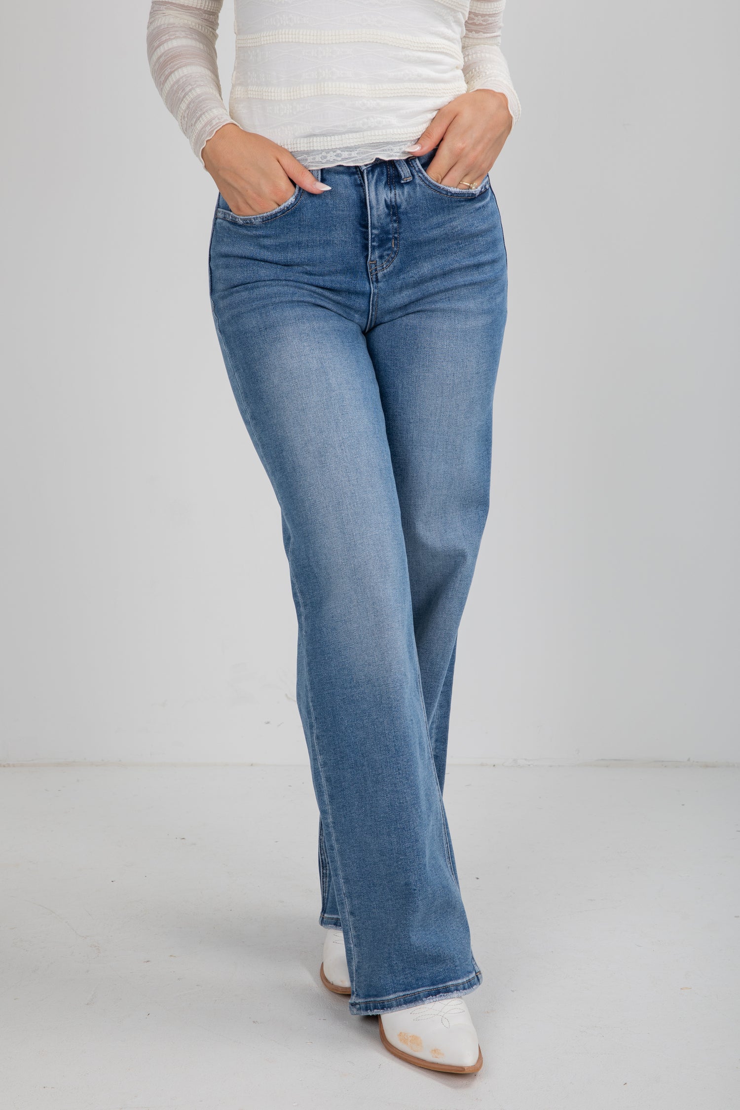 Person wearing blue jeans on a plain background