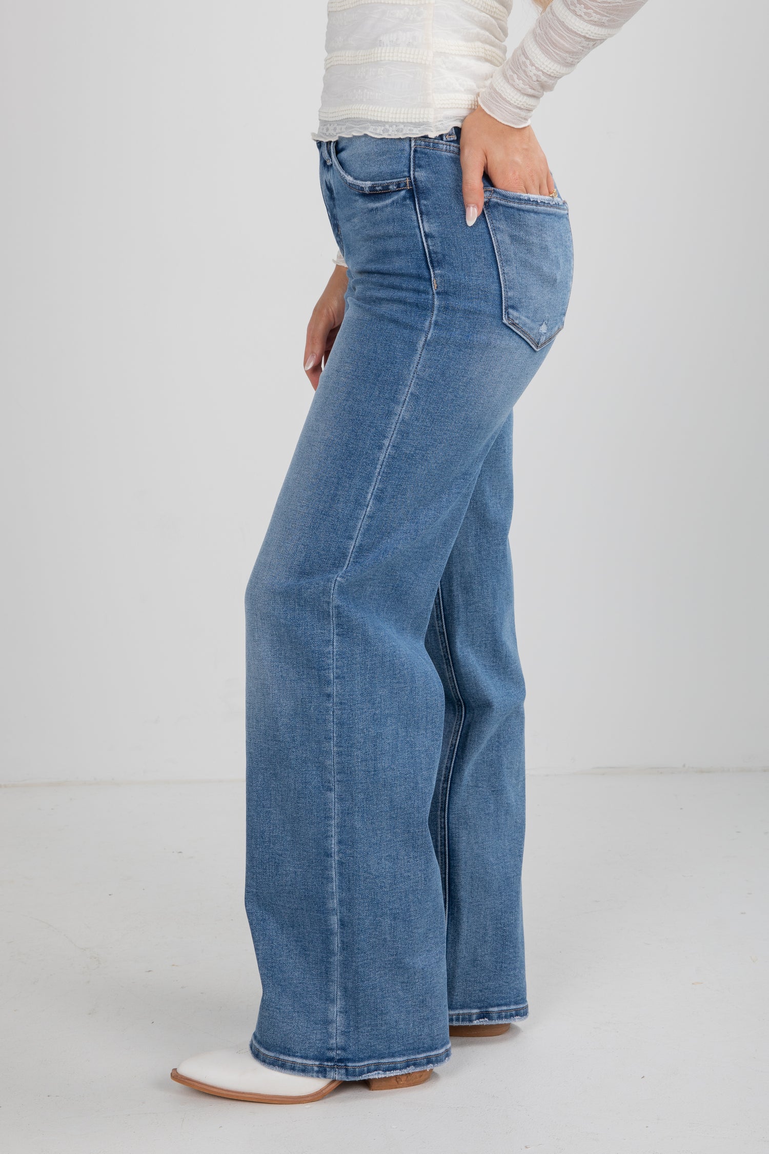 Blue jeans worn by a person on a white background