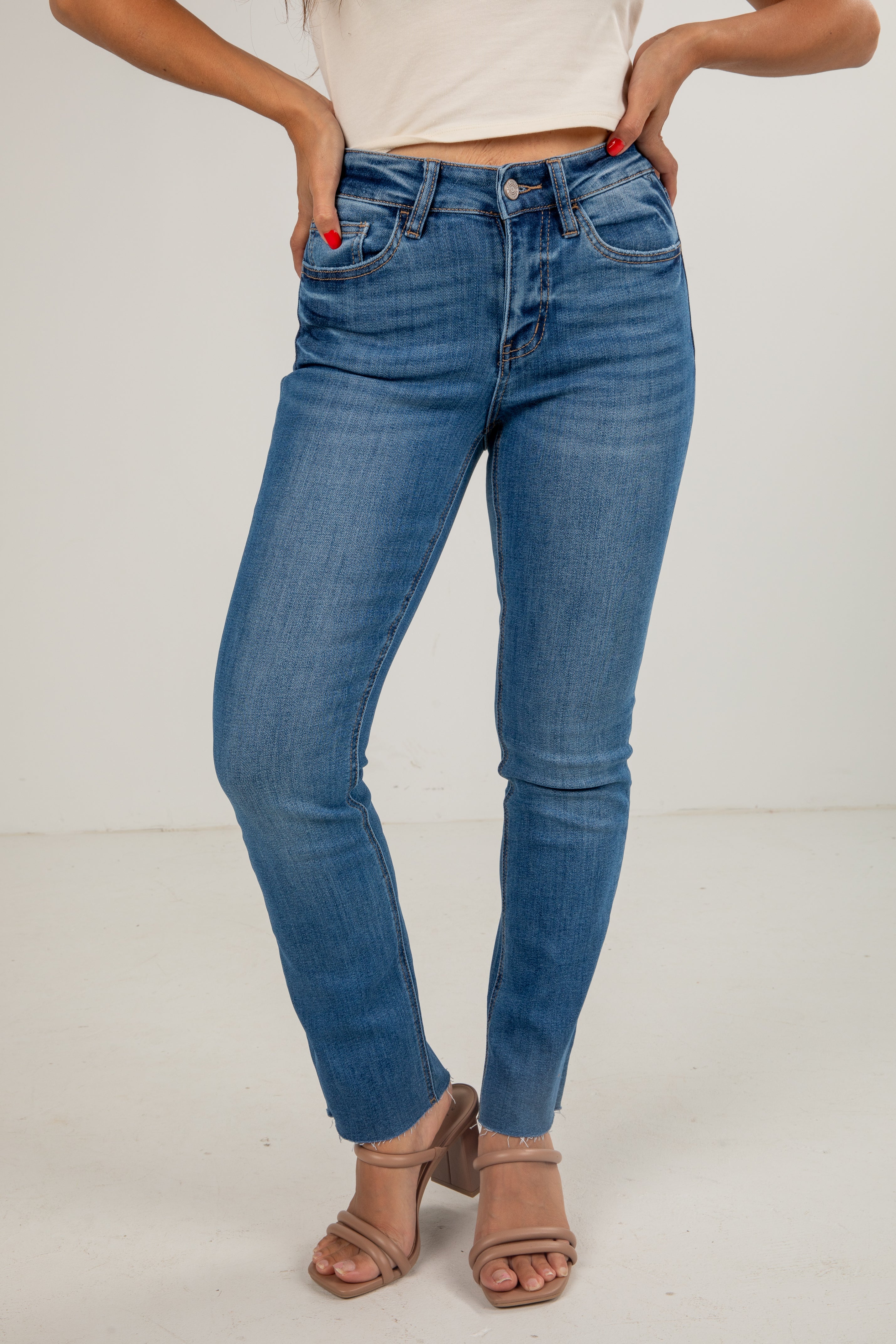 Person wearing blue jeans on a plain background