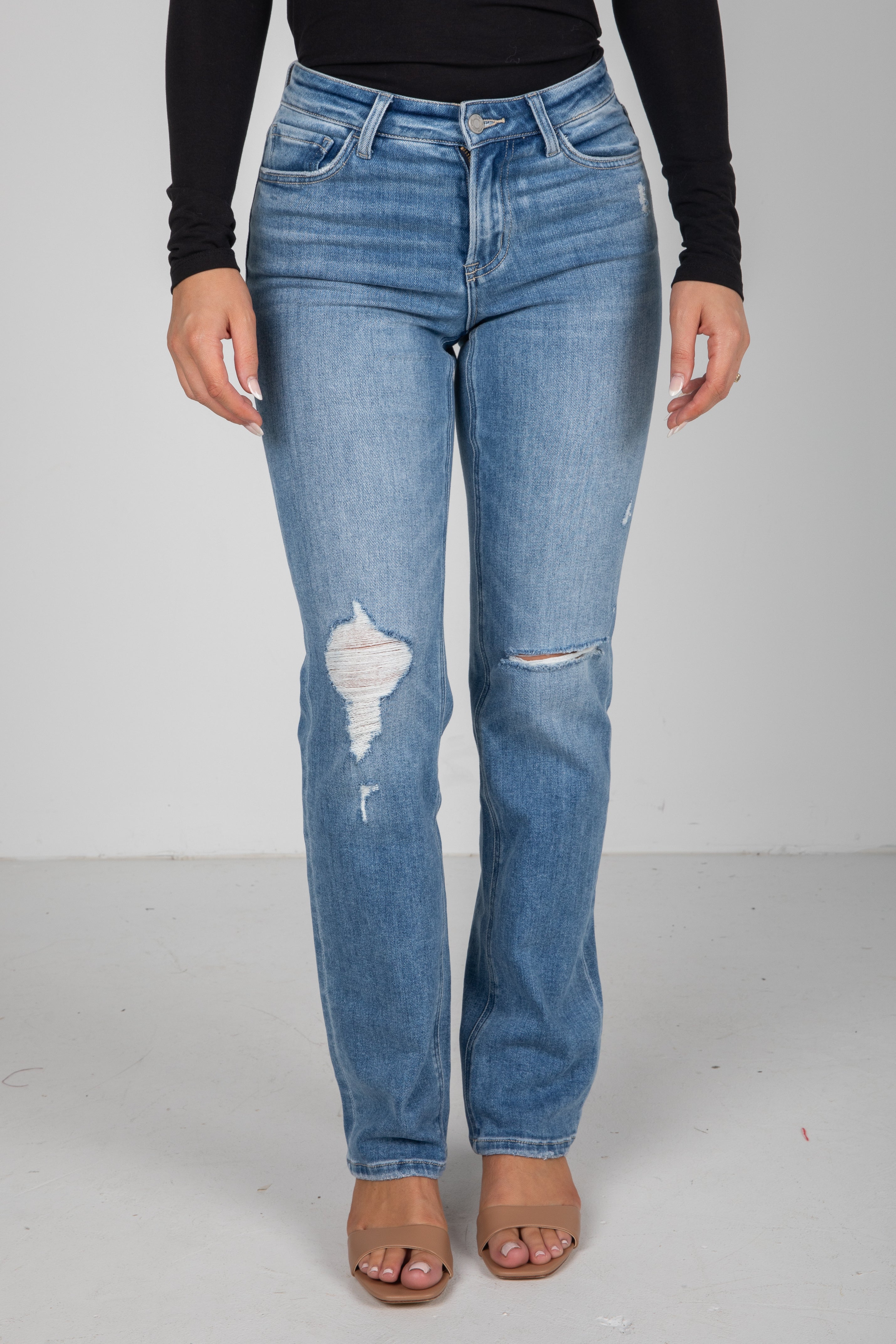 Blue jeans with slight distressing on a plain background