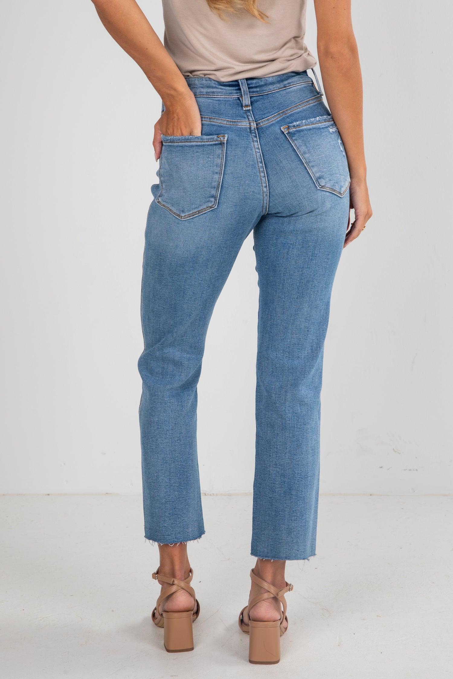 Person wearing blue jeans on a white background