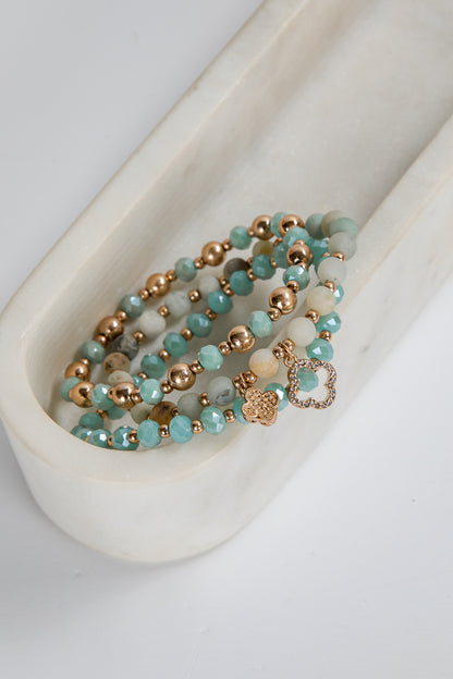 Turquoise and rose gold beaded bracelet on a white ceramic dish