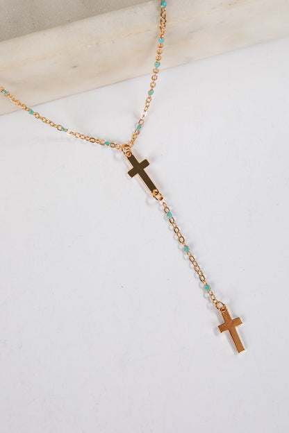 Necklace with gold crosses and turquoise beads on a white background