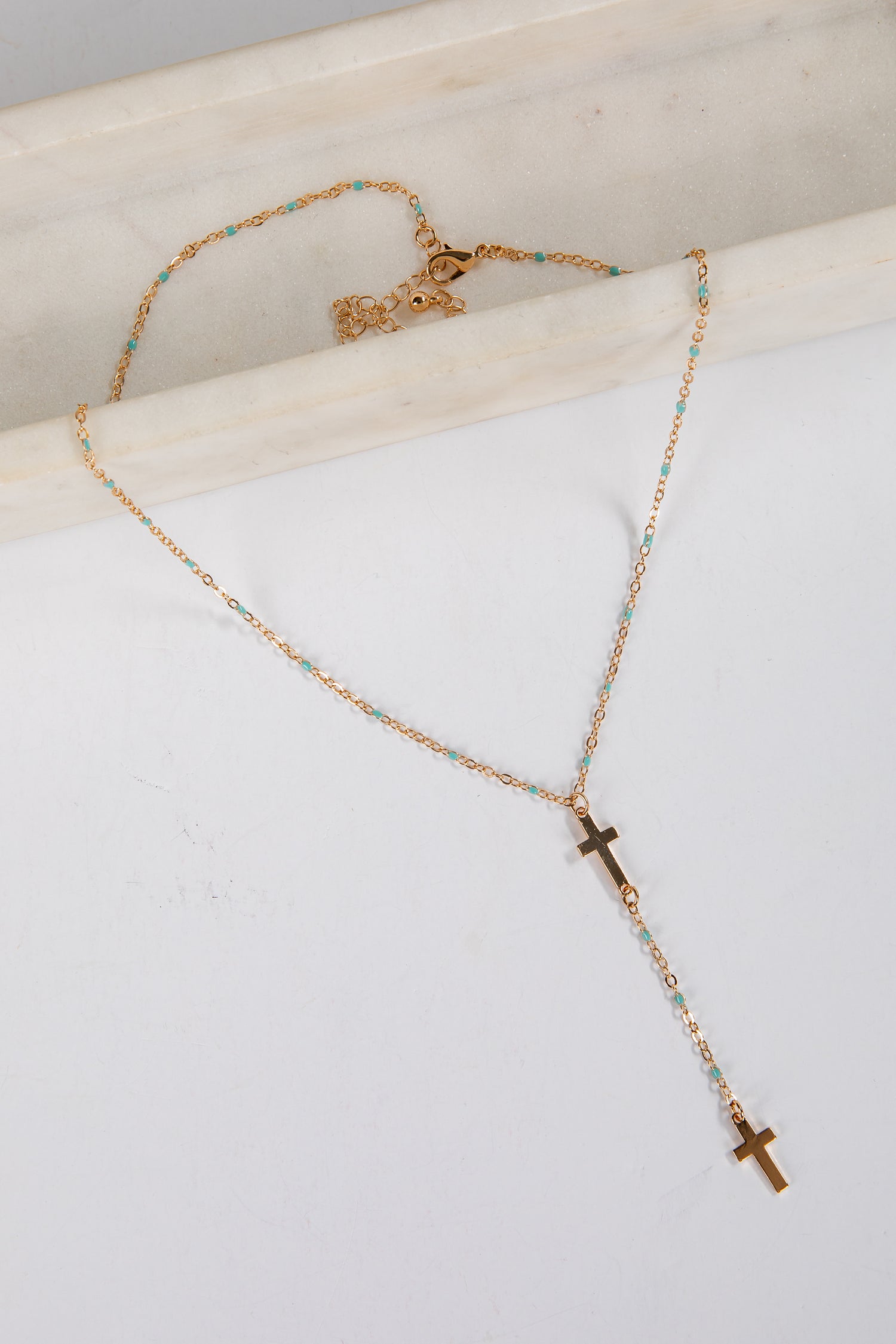 Necklace with cross pendants on a white surface