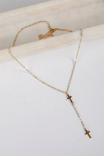 Necklace with cross pendants on a white surface
