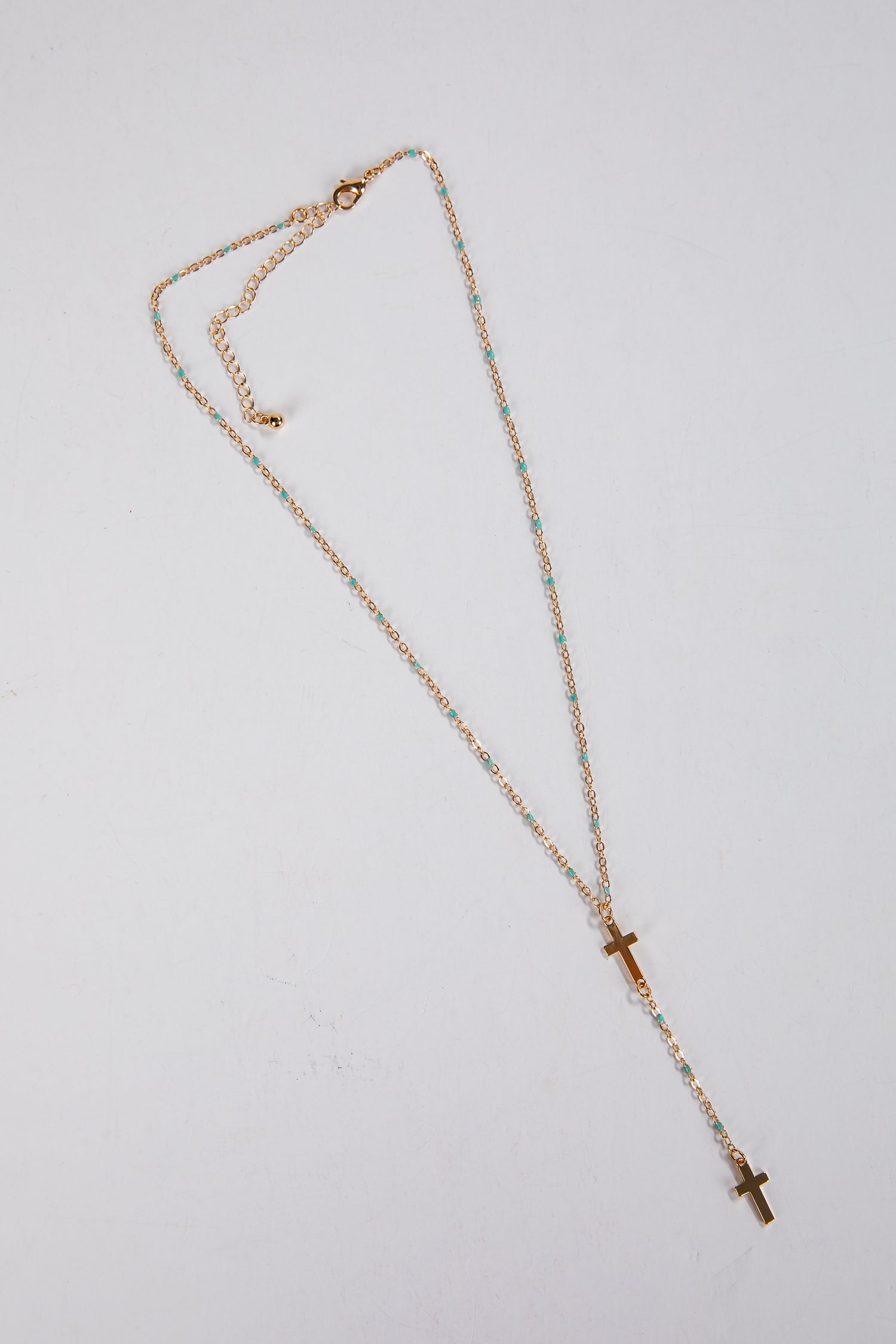 Necklace with a cross pendant on a light gray background
