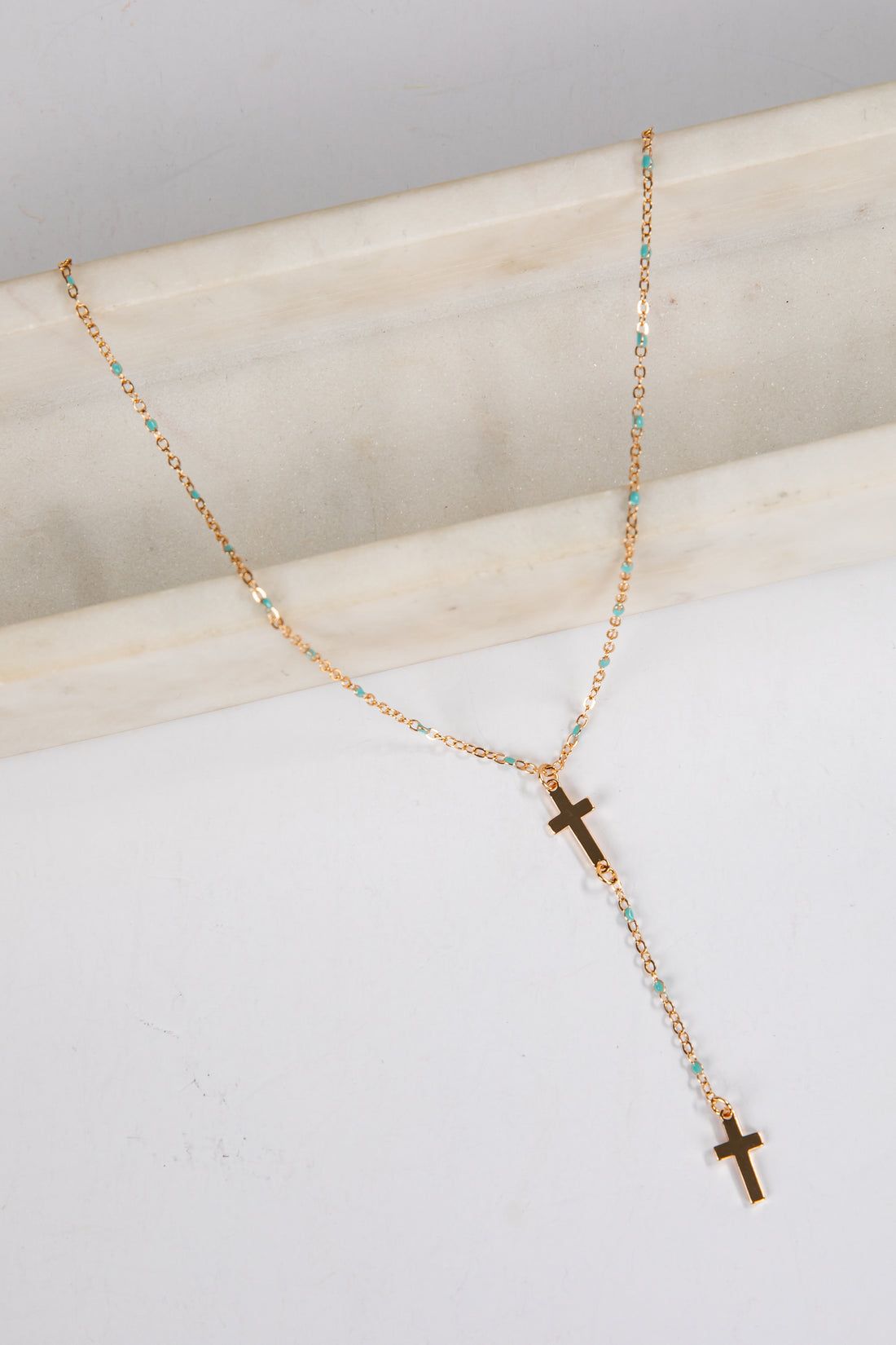 Necklace with cross pendants on a marble surface