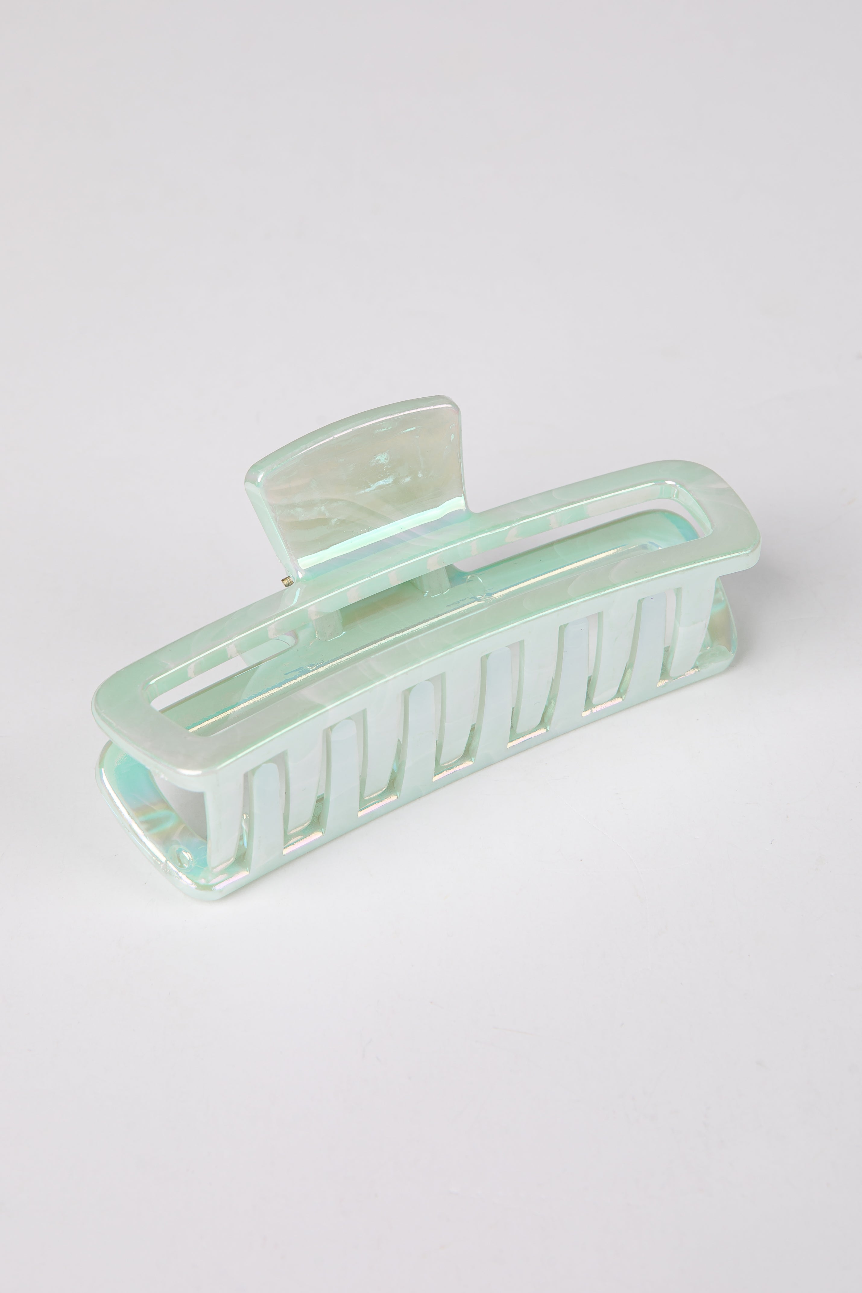Mint green hair clip on a light gray background