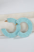 Turquoise hoop earrings on a white surface