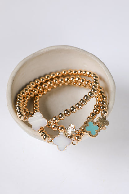 Gold bracelets with charms on a white background