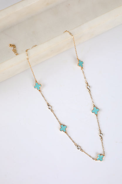Necklace with turquoise clover pendants on a white surface