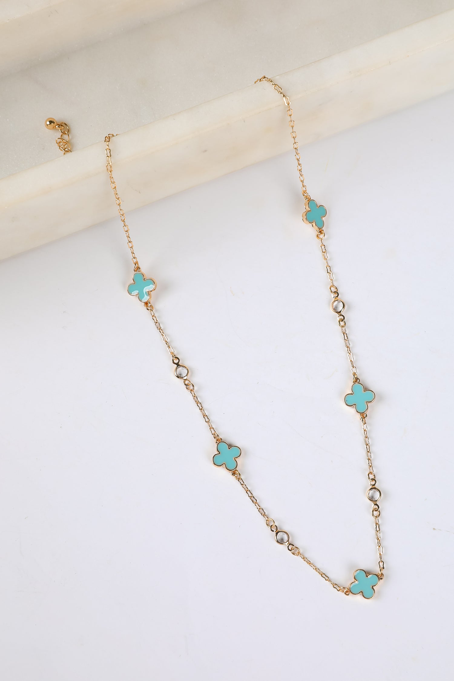 Necklace with turquoise flower-shaped pendants on a white background