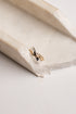 A delicate gold and silver twisted ring resting on a textured, off-white stone surface.
