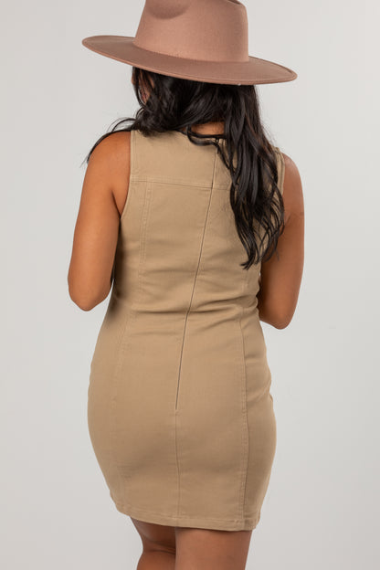 A woman shown from the back wearing a sleeveless beige bodycon mini dress and a matching wide-brim fedora hat against a light gray studio background.