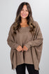 Woman wearing a brown poncho against a white background