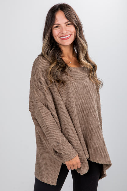Woman wearing a beige sweater against a white background