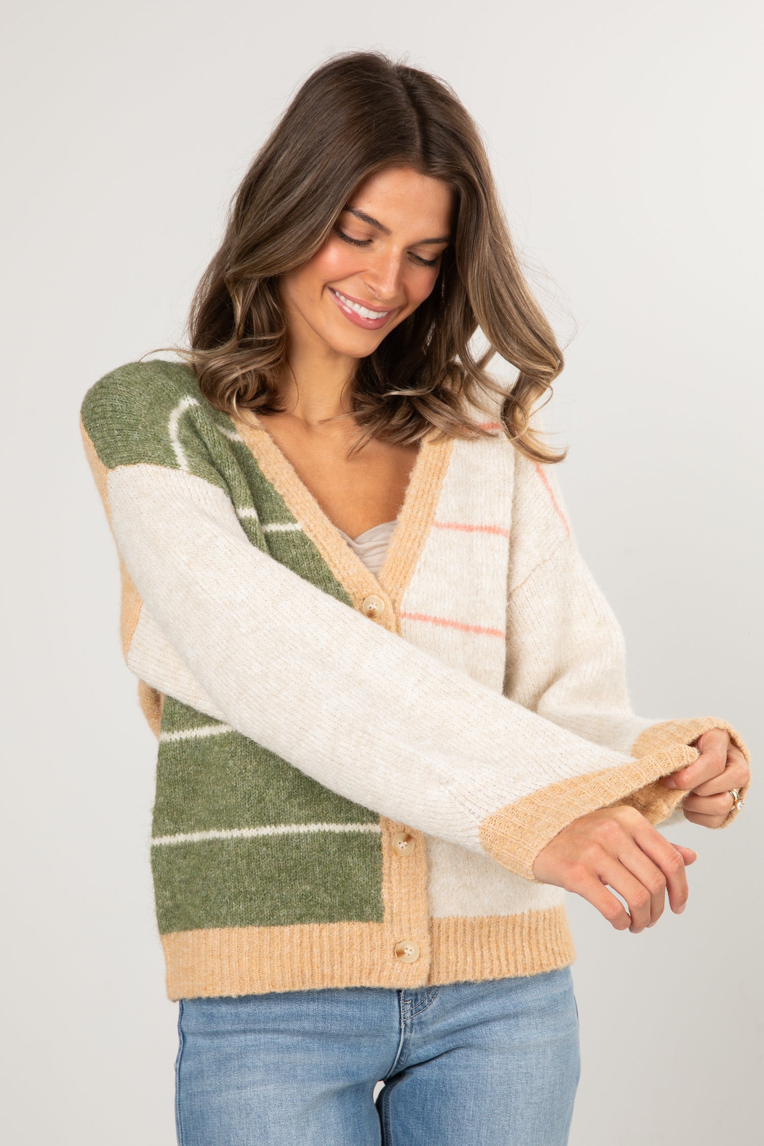 Woman wearing a colorful cardigan with a neutral background