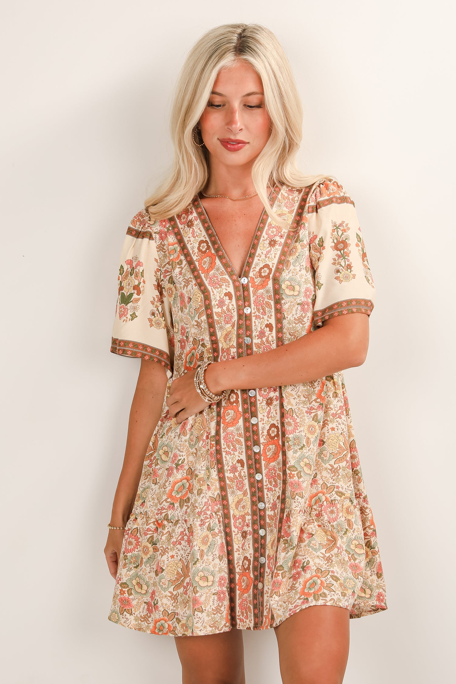 Woman wearing a floral patterned dress against a white background