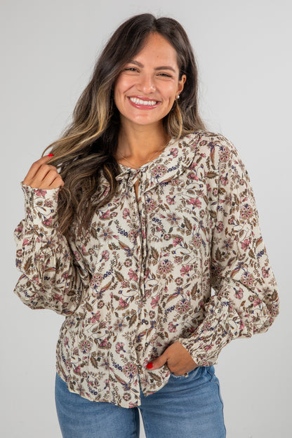 Woman wearing a floral blouse with a plain background