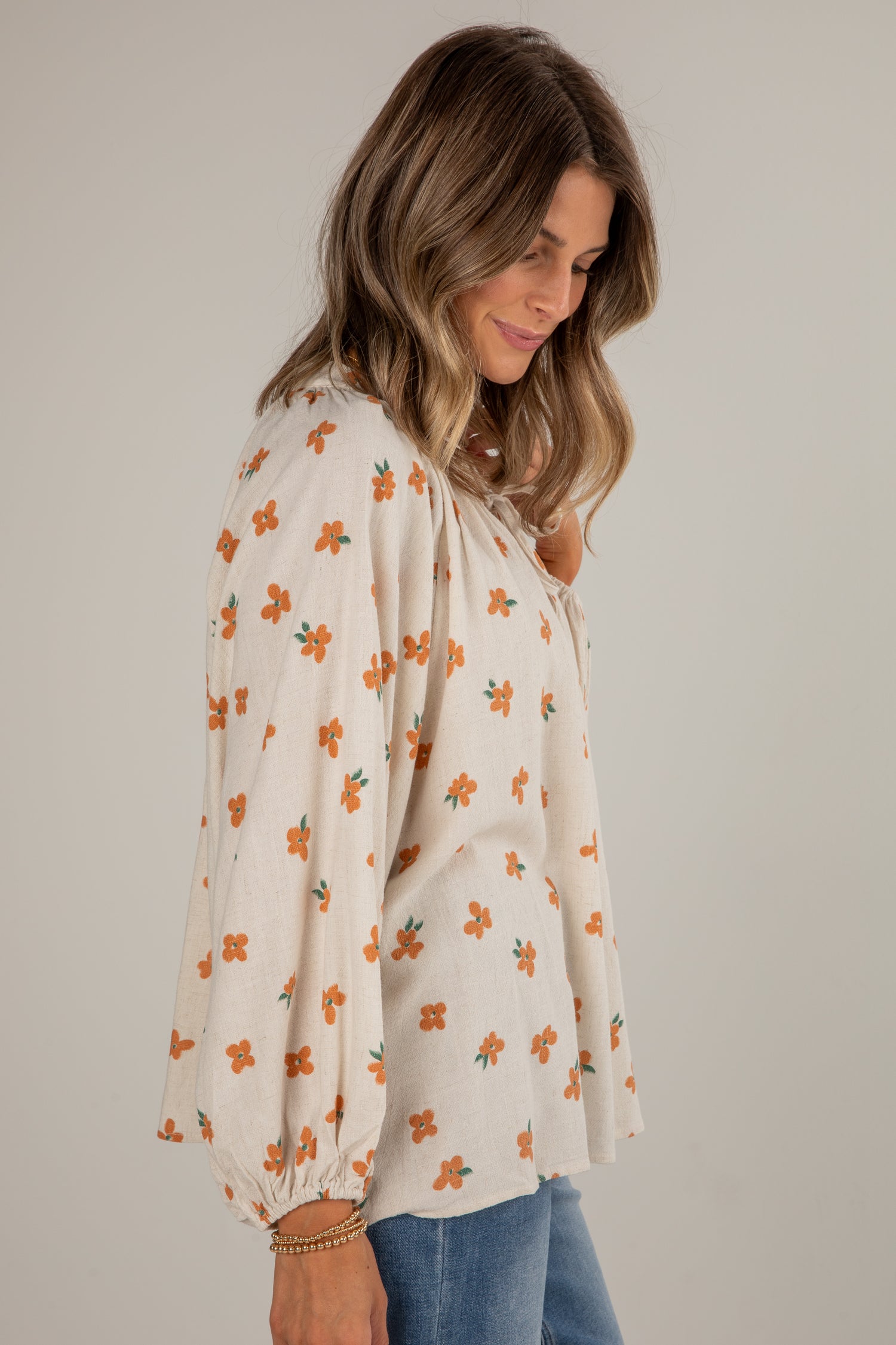 Woman wearing a floral blouse with a plain background