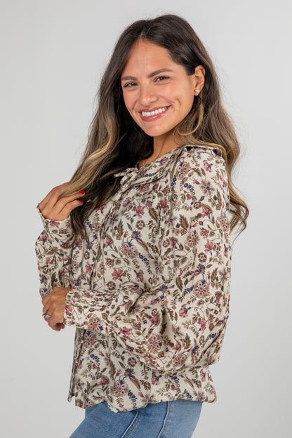 Woman wearing a floral blouse with a plain background