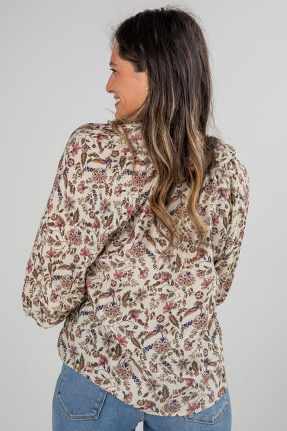 Woman wearing a floral blouse with a plain background