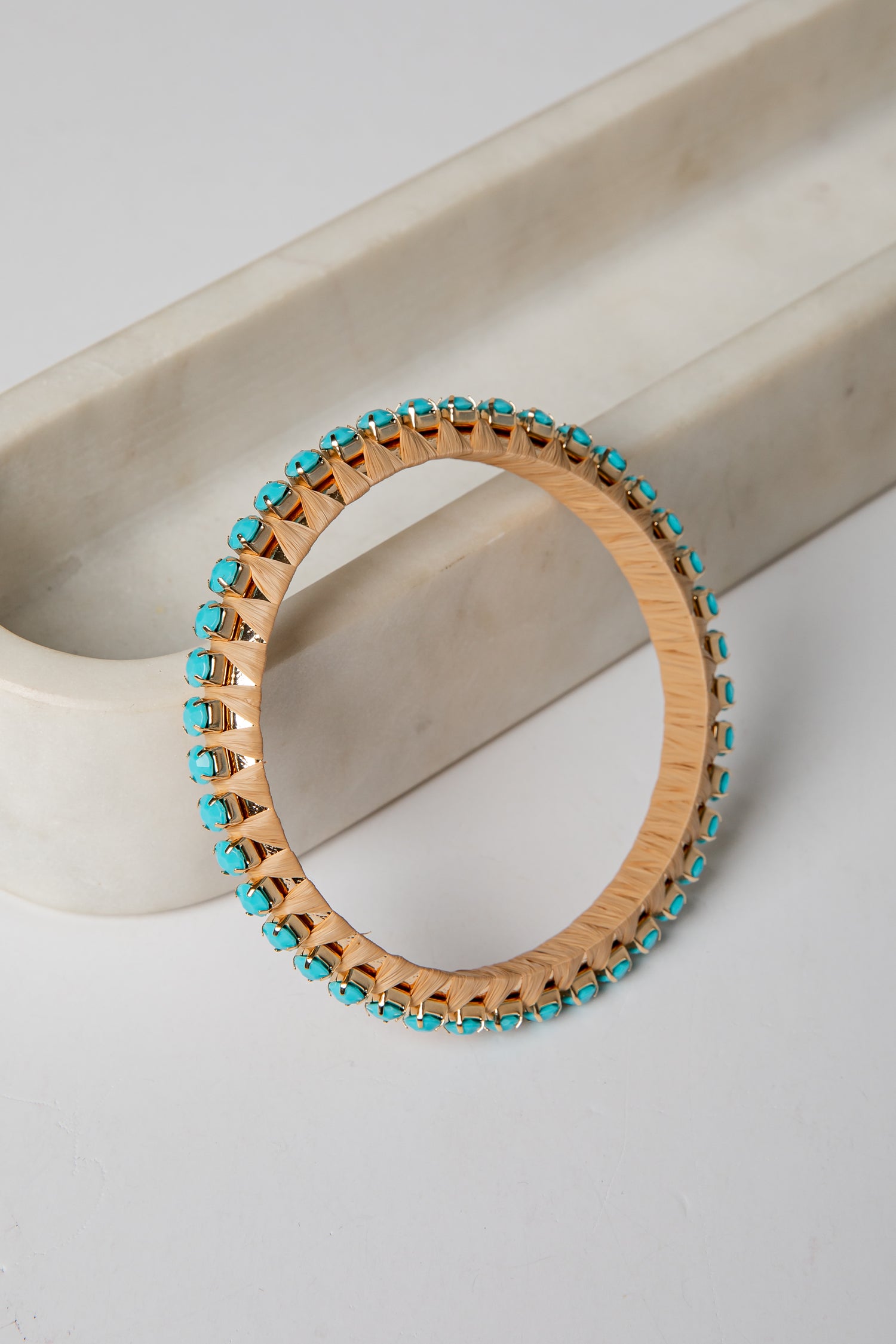 Wooden bracelet with turquoise beads on a light background