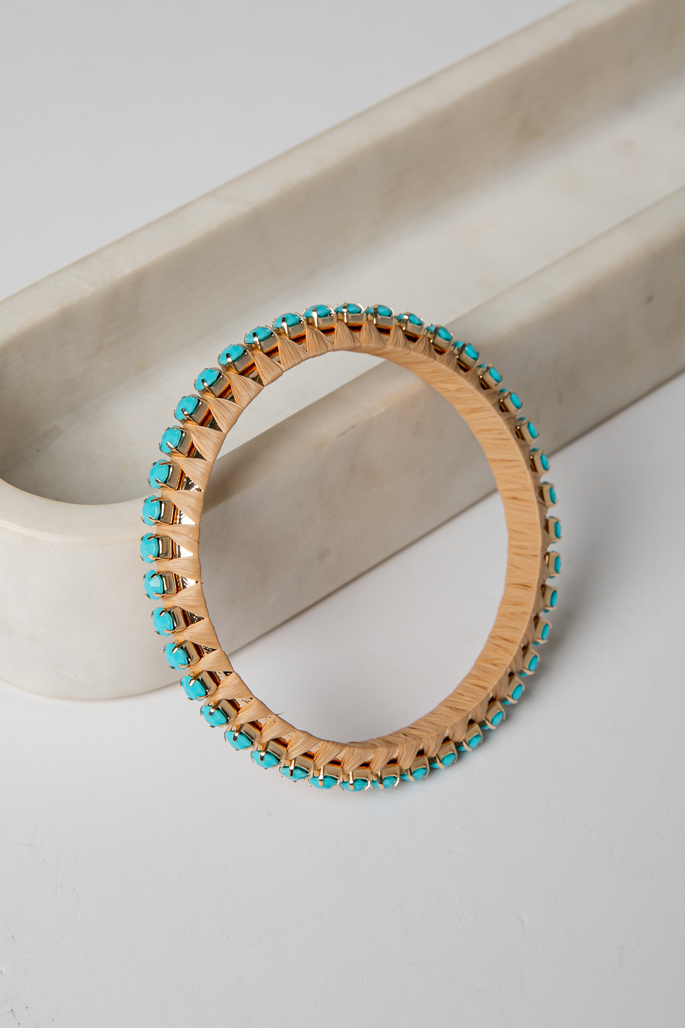 Wooden bracelet with turquoise beads on a light background