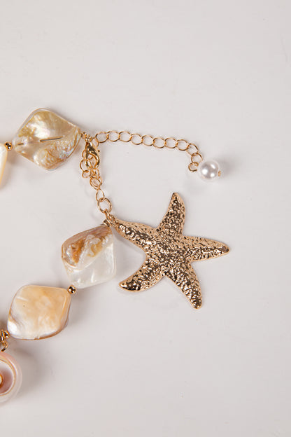Bracelet with starfish and shell charm on a light background