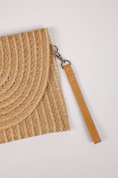 Close-up of a woven beige bag with a leather strap on a light gray background