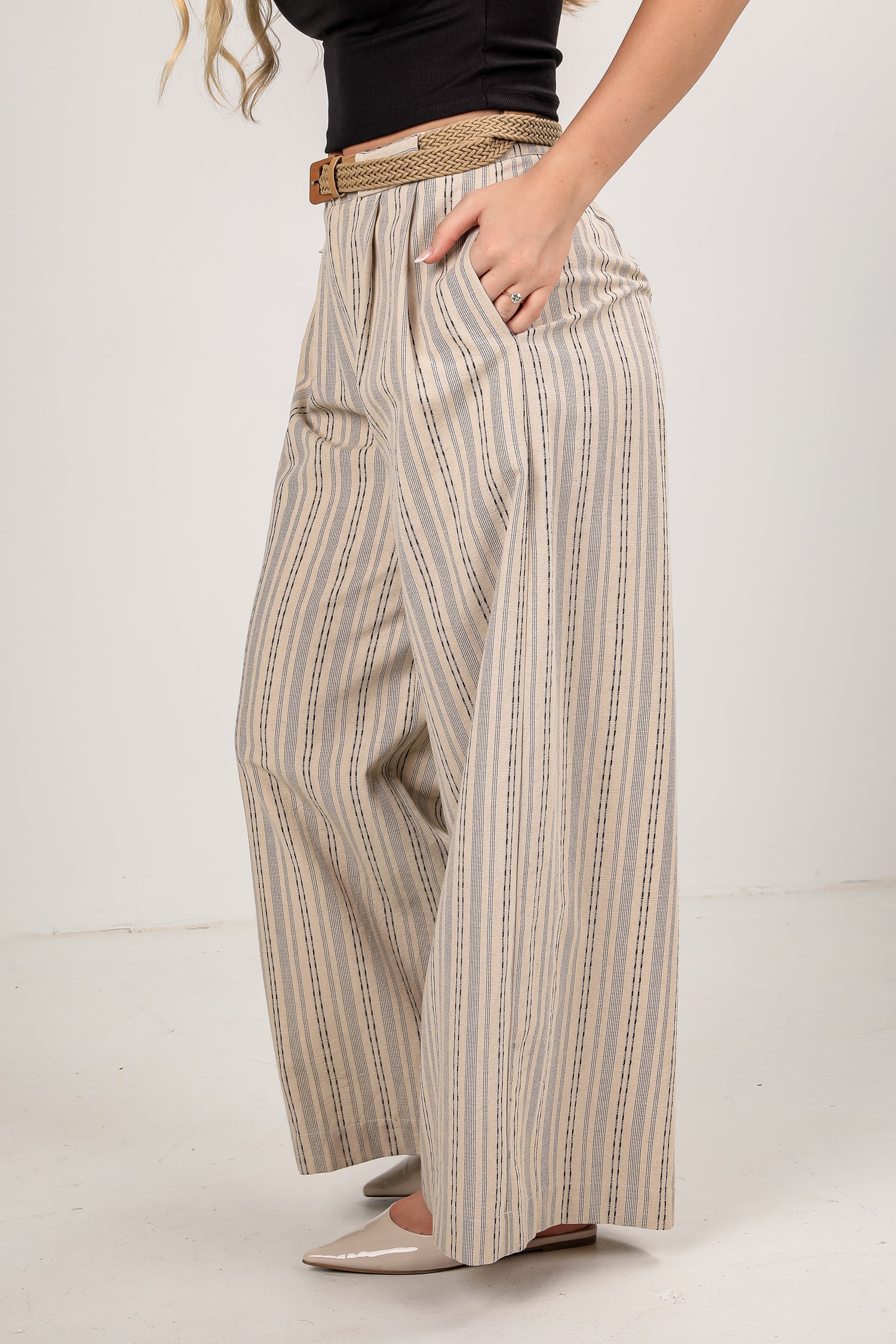 Person wearing striped wide-leg pants with a plain background