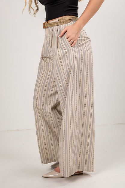 Person wearing striped wide-leg pants with a plain background