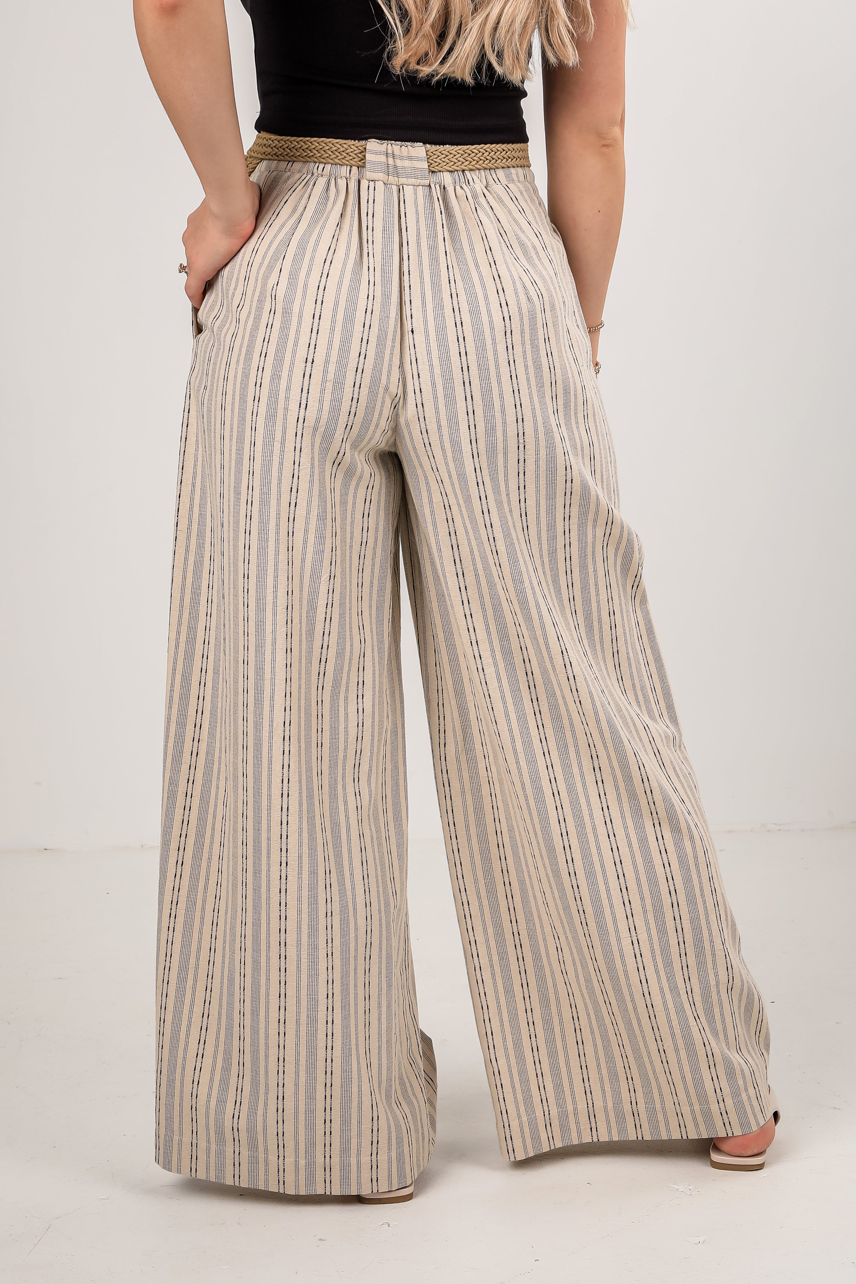 Person wearing wide-leg striped pants on a plain background