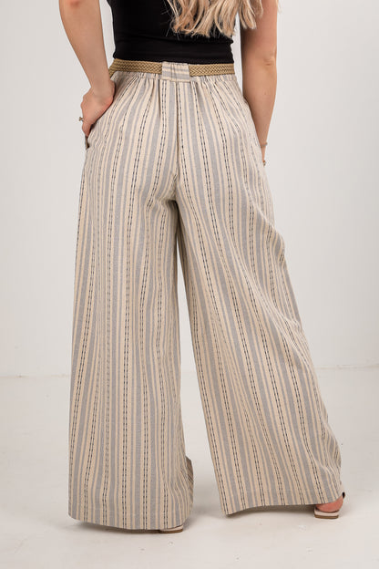 Person wearing wide-leg striped pants on a plain background