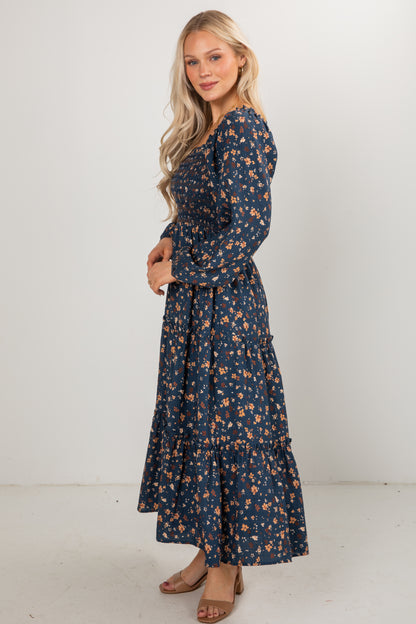 Woman wearing a navy floral dress against a white background