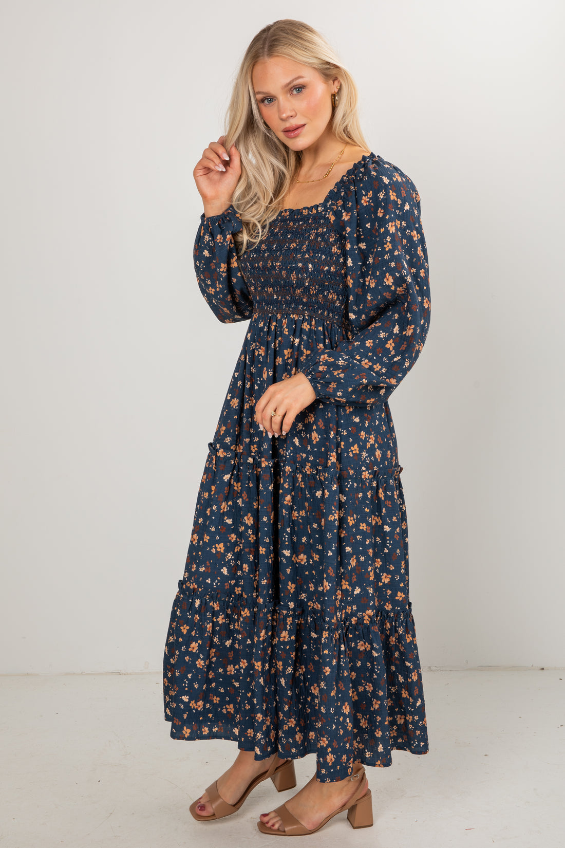 Woman wearing a navy floral dress against a white background