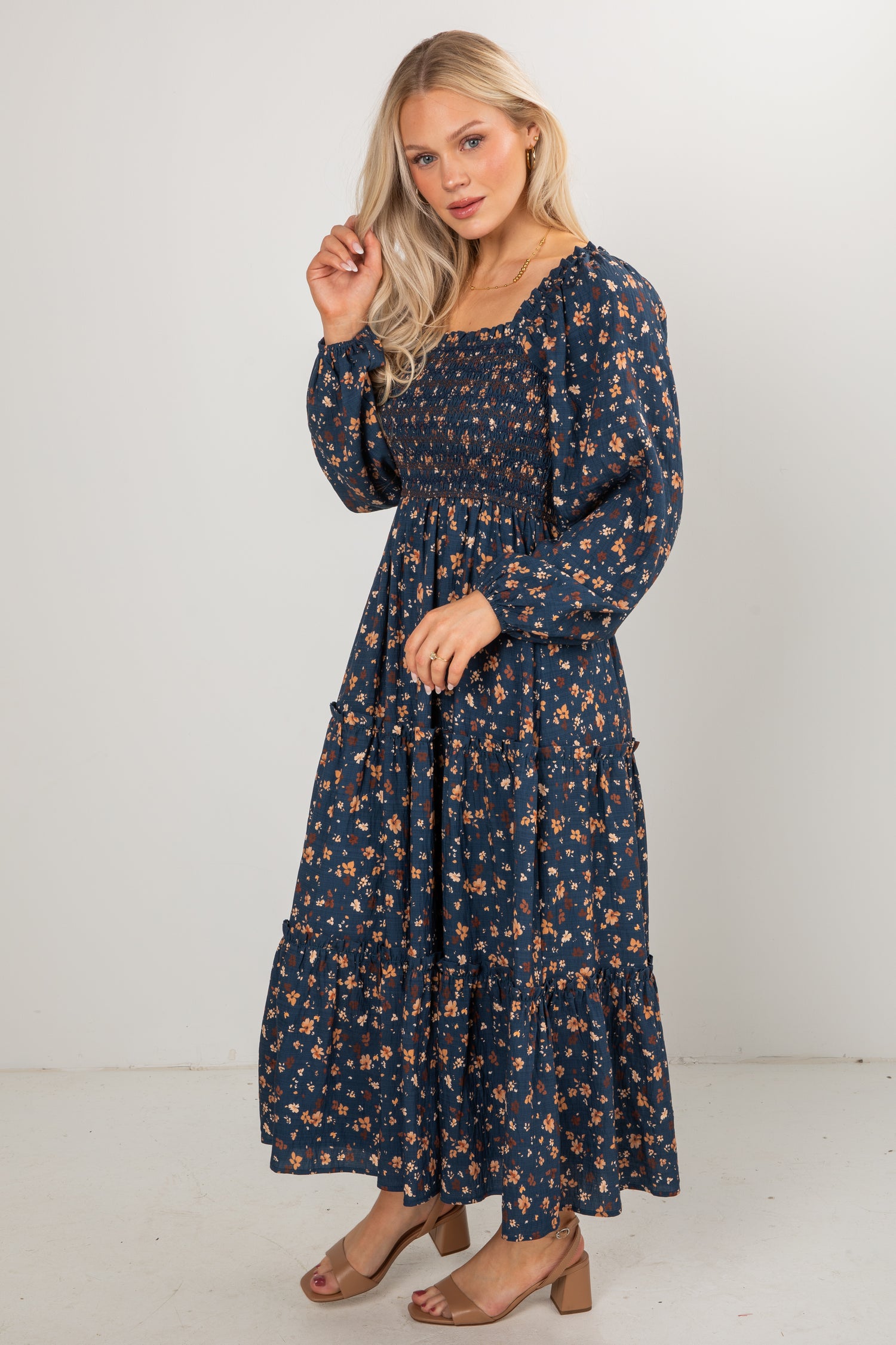 Woman wearing a navy floral dress against a white background