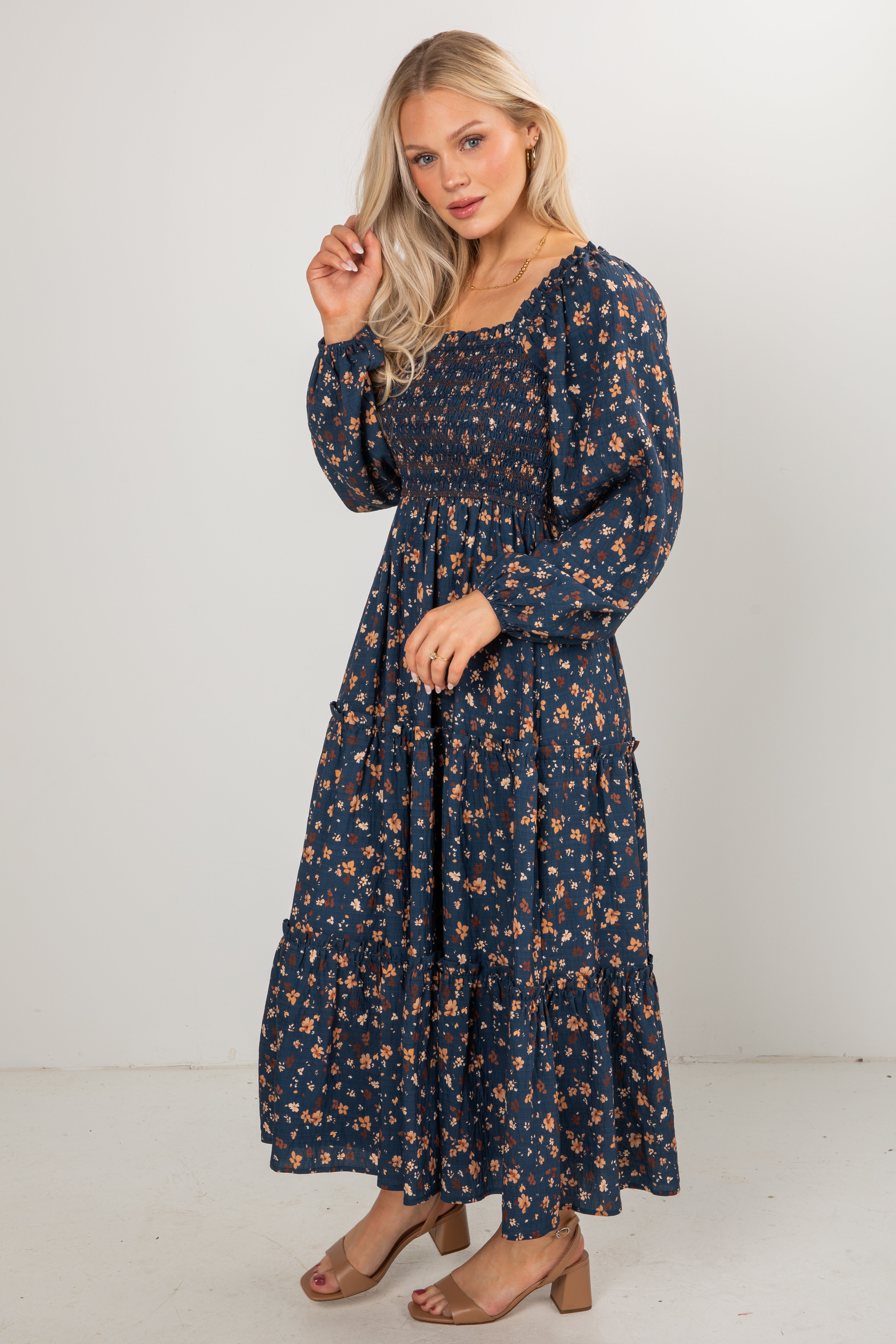 Woman wearing a navy floral dress against a white background