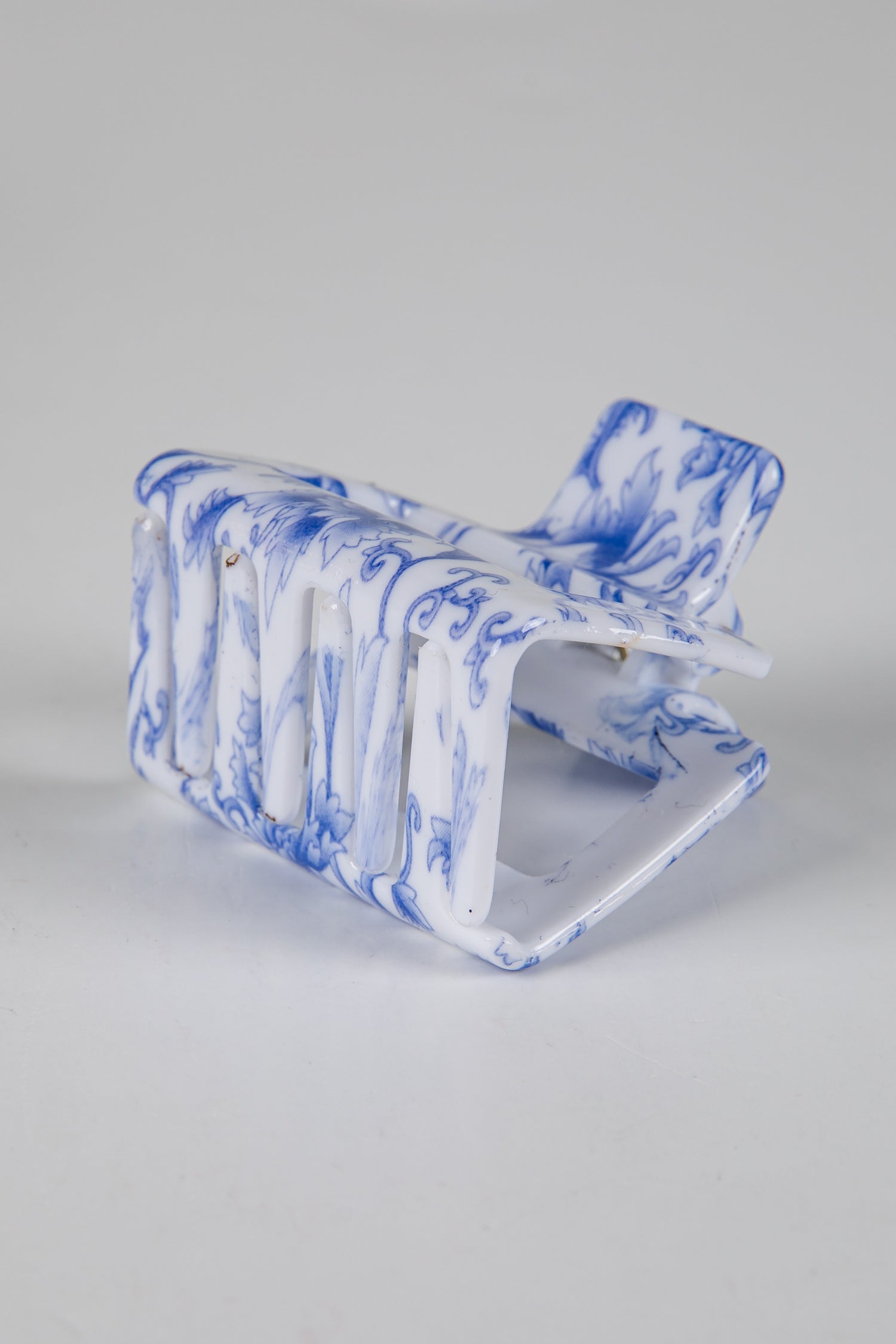 Blue and white marbled clutch bag on a light gray background