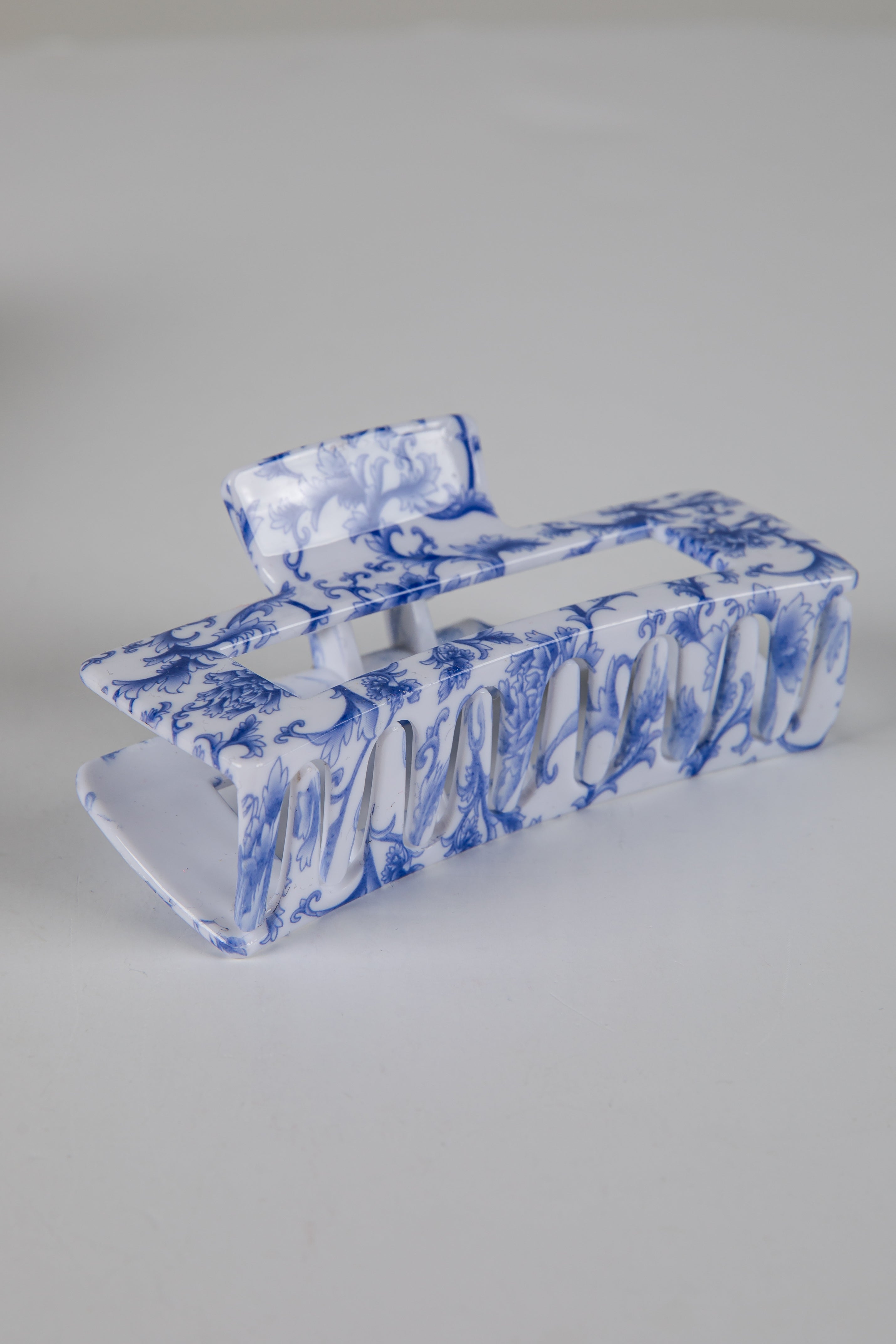 Blue and white marbled hair clip on a gray background