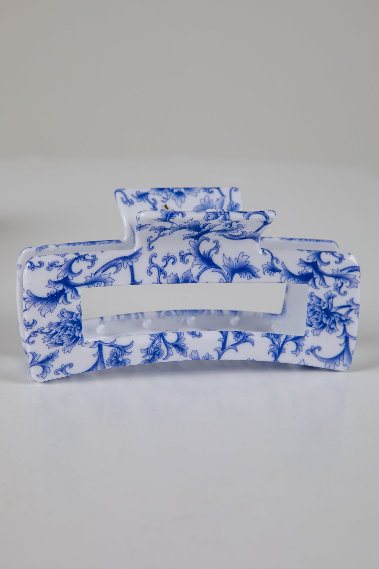 Blue and white floral-patterned tissue holder on a gray background