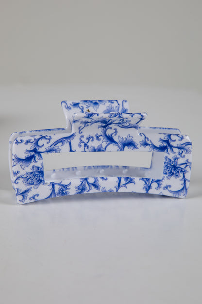 Blue and white floral-patterned tissue holder on a gray background