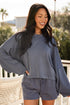 Woman wearing a blue outfit with a blurred outdoor background