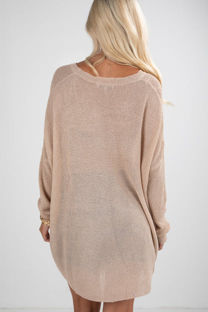 Beige sweater worn by a person on a white background