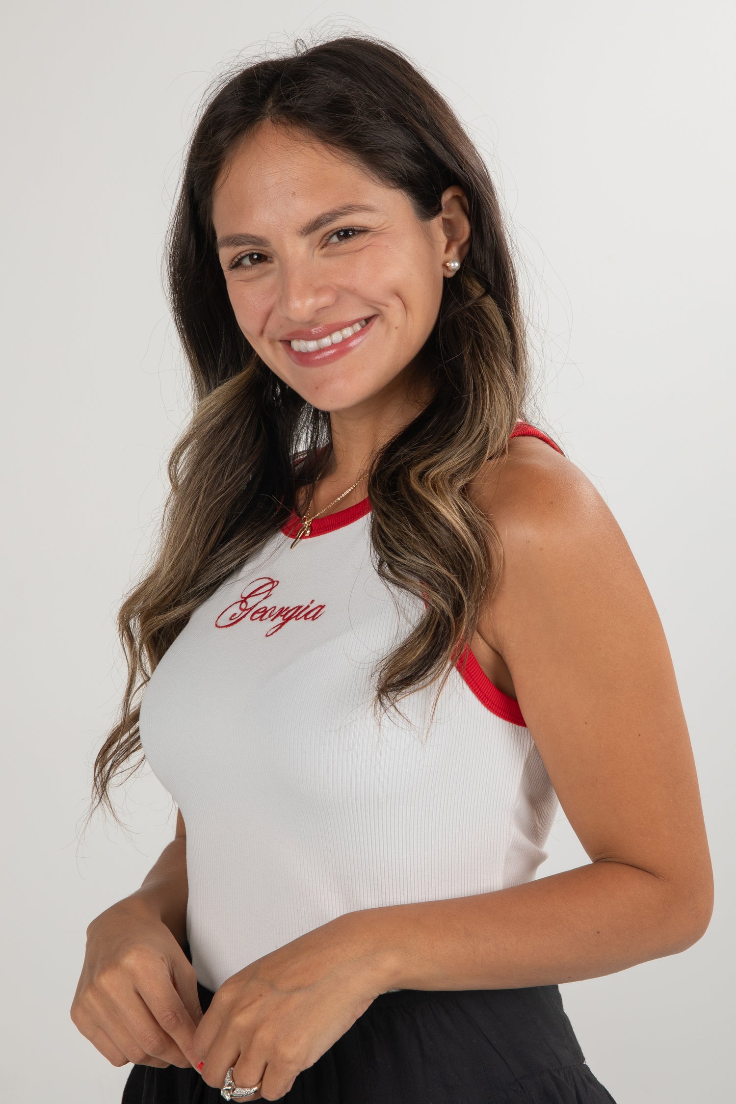 Woman wearing a white tank top with red accents and &