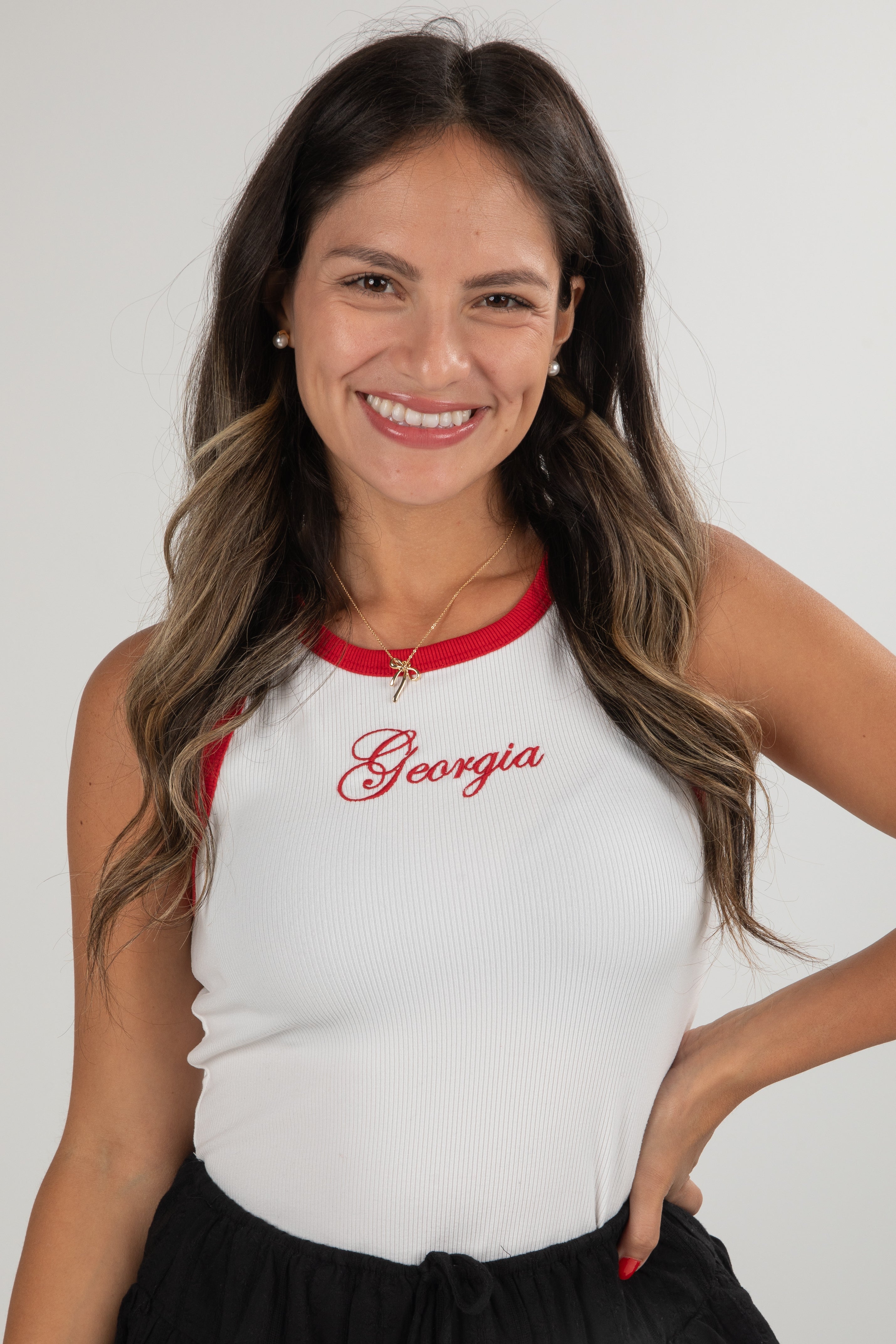 Woman wearing a white tank top with red trim and &